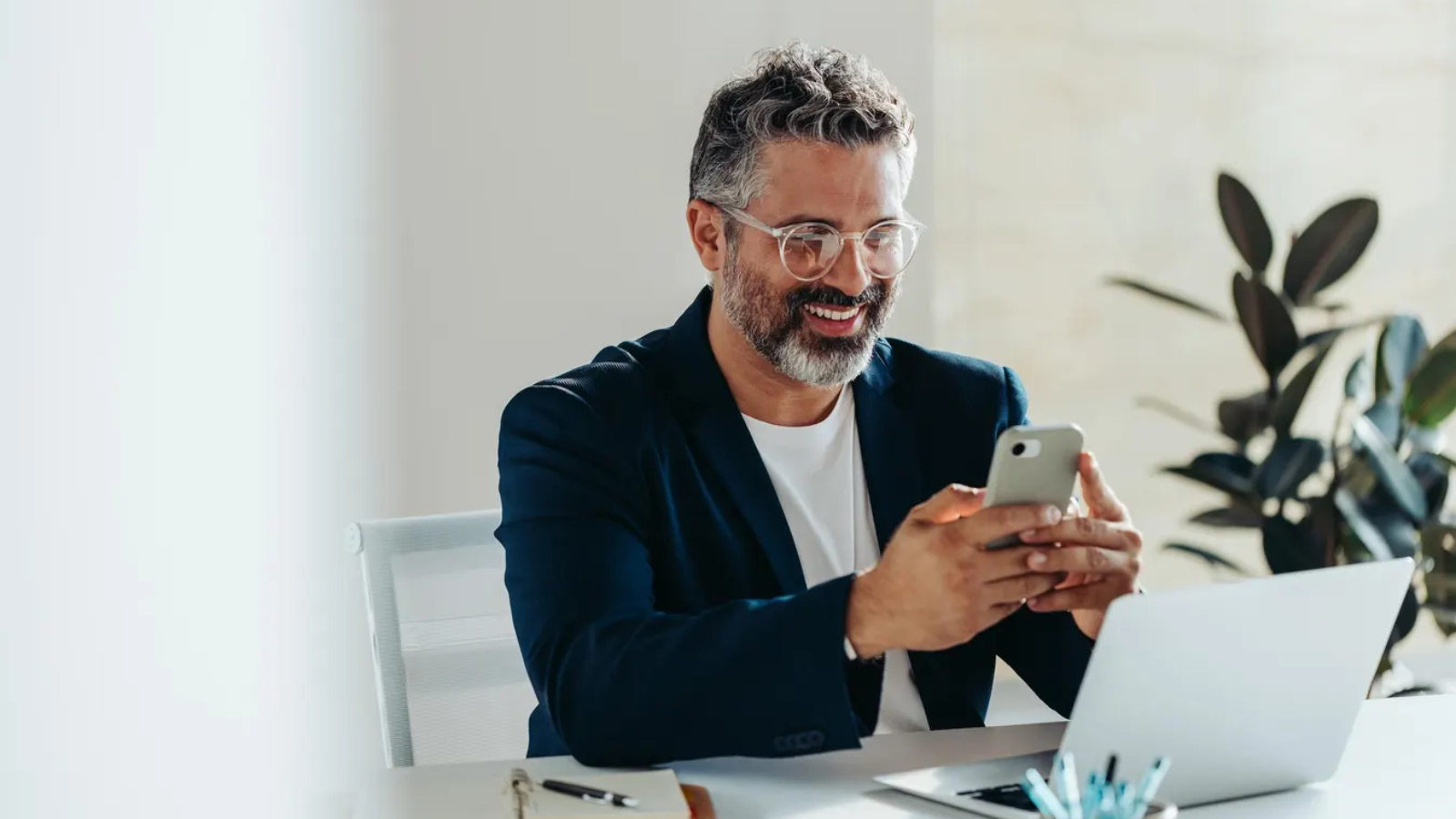 694363c9535c22837ee5ec92_Business owner looking at phone happy with results from web design