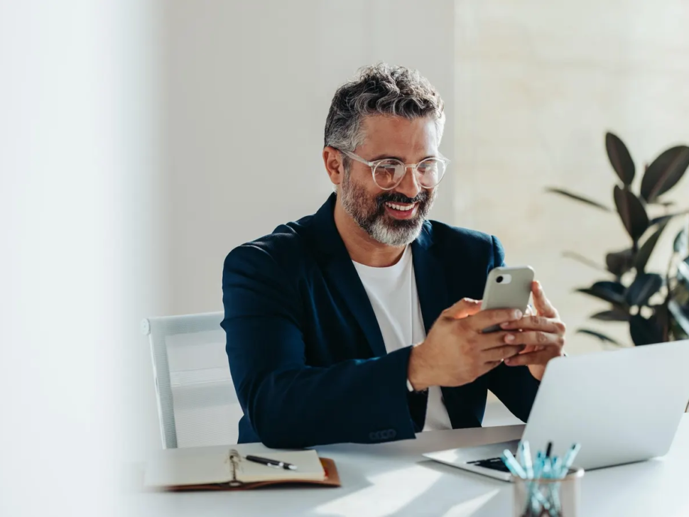 694363c9535c22837ee5ec92_Business owner looking at phone happy with results from web design